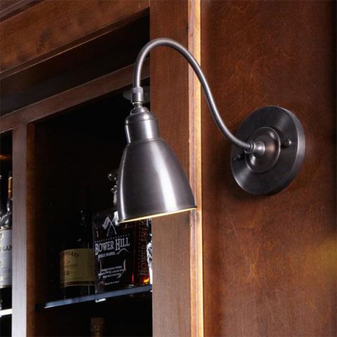 One Light Goose Neck Sconce with Articulated Metal Shade in Architectural Bronze lights a bar