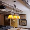 Three light linear chandelier with sheepskin shades llights a lower level rec room pool table